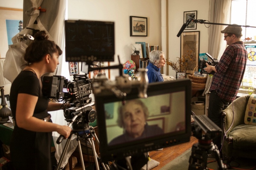 A small crew filming an interview in a living room